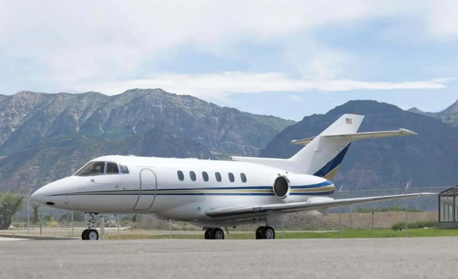Private jet on a runway in front of a mountain range