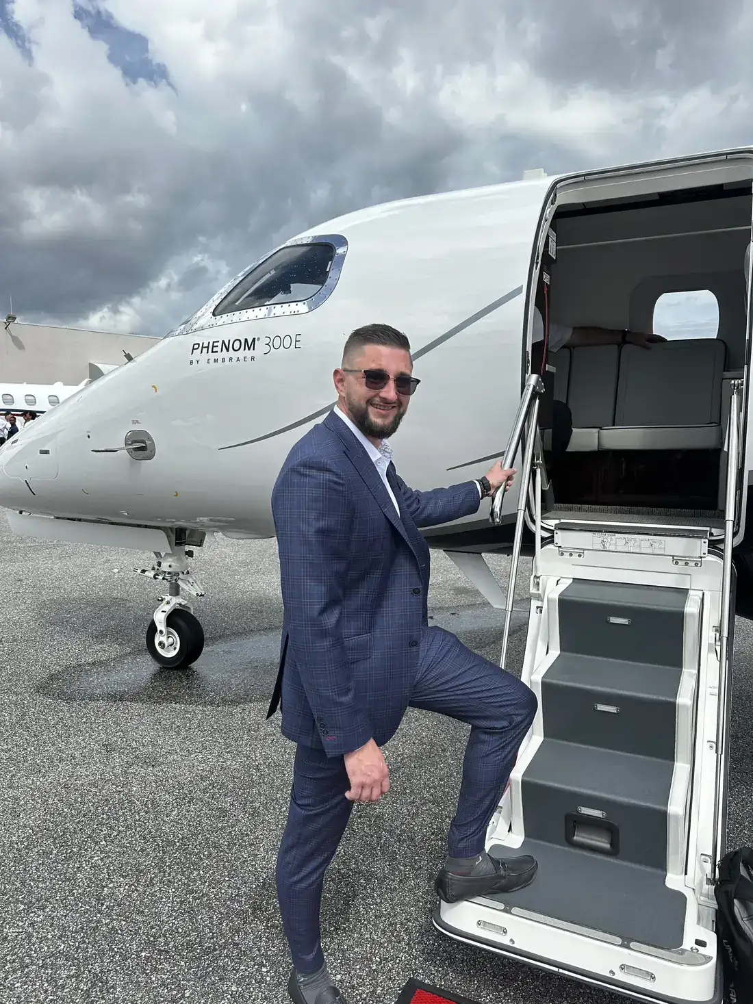 Zach Purvis on the stairs of a Phenom 300E private jet